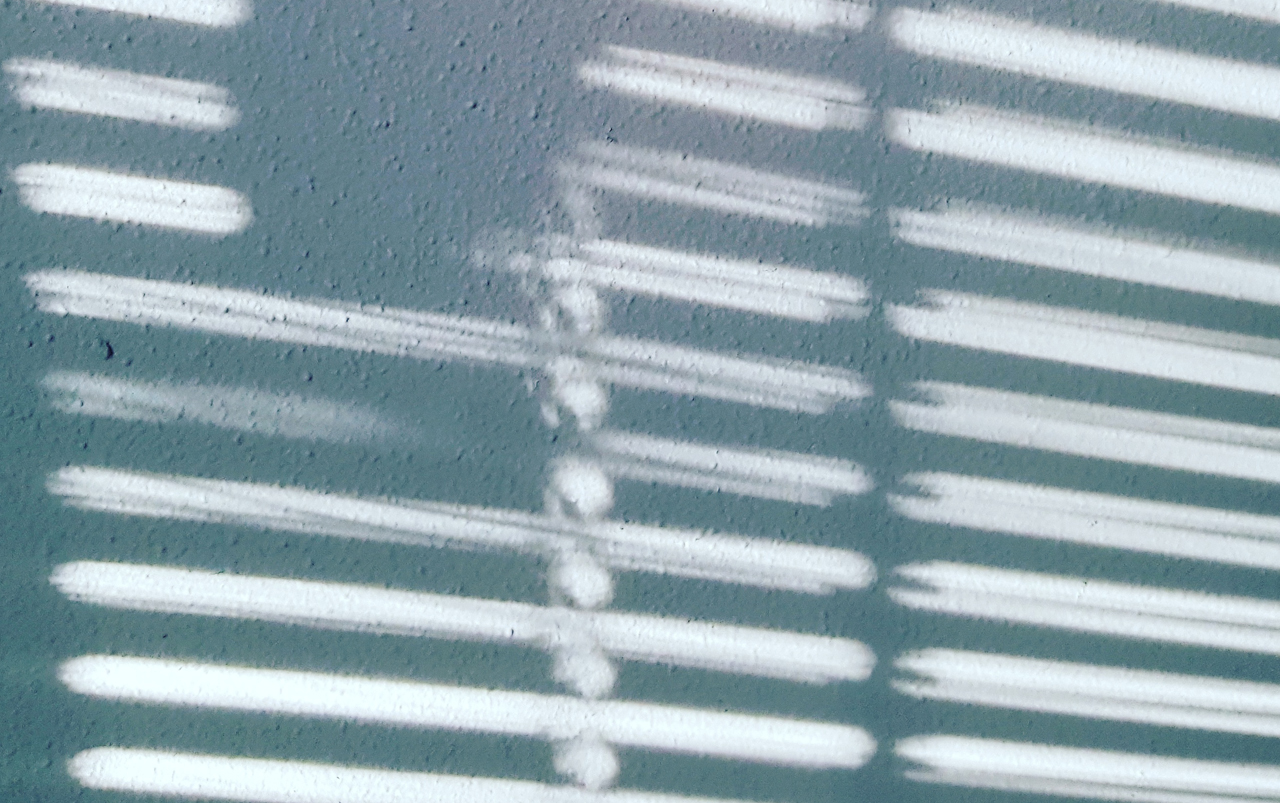 Shadow of vertical window blinds on light blue wall